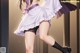 A woman in a purple dress and black stockings is dancing.