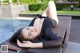 A woman laying on a lounge chair next to a swimming pool.