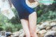 A woman in a blue bathing suit standing in a stream.