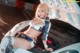 A woman in a bikini sitting on top of a car.