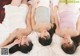 A group of three women laying on top of a bed.