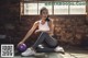 A woman sitting on the floor with a purple ball.