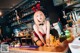 A woman in a red lingerie sitting at a bar.